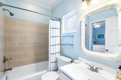a bathroom with a sink toilet and a mirror at Beach Bummin' - Week long stays get 4 free bikes rental! in Rosemary Beach