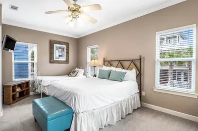a bedroom with two beds and a ceiling fan at Beach Bummin' - Week long stays get 4 free bikes rental! in Rosemary Beach
