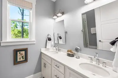 a white bathroom with two sinks and a mirror at Amaryllis Point - 30A, Private Pool, Bicycles, 3 King Masters! in Rosemary Beach