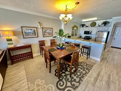 a dining room and kitchen with a table and chairs at Ocean Reef 1607 in Panama City Beach