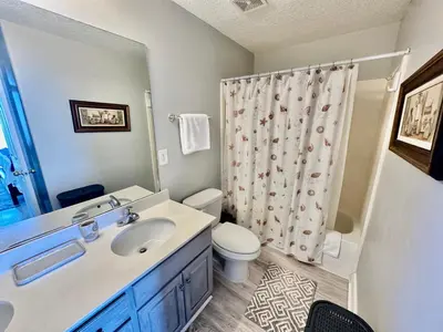 a bathroom with a sink and a toilet with a shower curtain at Ocean Reef 1607 in Panama City Beach