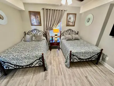 a bedroom with two beds and a window at Ocean Reef 1607 in Panama City Beach