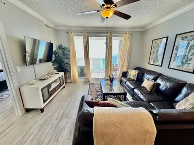 a living room with a couch and a flat screen tv at Ocean Reef 1607 in Panama City Beach