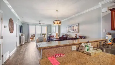 a kitchen and living room with a couch and a sink at Tropic Winds 2101 in Panama City Beach