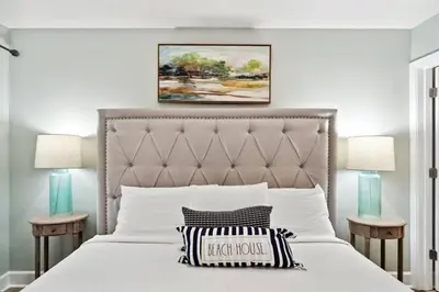 a bedroom with a white bed with two night stands at Tidewater 1406 in Panama City Beach