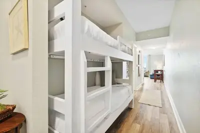 a bedroom with a white bunk bed in a room at Tidewater 1406 in Panama City Beach