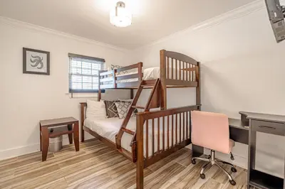 a bedroom with a bunk bed and a desk at Bayview Cottage - Sun deck, pool, and more! in Panama City Beach