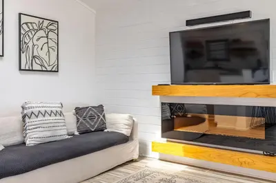 a living room with a fireplace and a tv at Bayview Cottage - Sun deck, pool, and more! in Panama City Beach