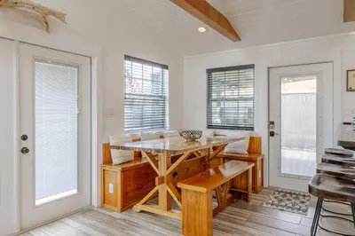 a dining room with a table and some windows at Bayview Cottage - Sun deck, pool, and more! in Panama City Beach