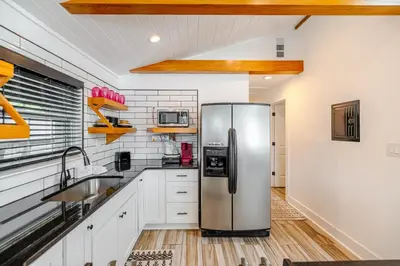 a kitchen with a stainless steel refrigerator at Bayview Cottage - Sun deck, pool, and more! in Panama City Beach