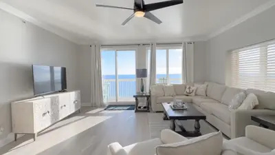 a living room with a couch and a flat screen tv at Calypso 1-1709 by Emerald Coast Retreats in Panama City Beach