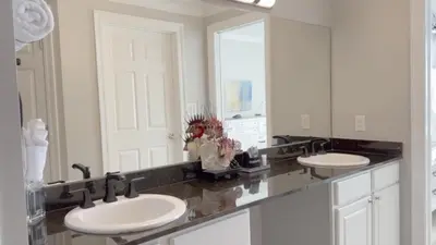 a bathroom with two sinks and a large mirror at Calypso 1-1709 by Emerald Coast Retreats in Panama City Beach