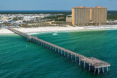 an aerial view of a pier over the ocean with a beach at Calypso 1-1709 by Emerald Coast Retreats in Panama City Beach