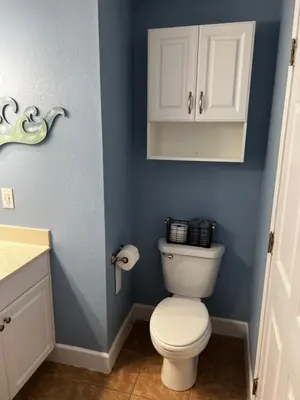 a bathroom with a white toilet and blue walls at Panama City Beach, Beach Front Condo 207 in Panama City Beach