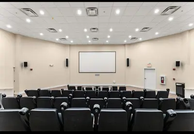 an empty lecture hall with a white screen and chairs at Panama City Beach, Beach Front Condo 207 in Panama City Beach