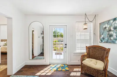 a living room with a mirror and a chair at a block away from beach/Harbor/Fine restaurants in Panama City