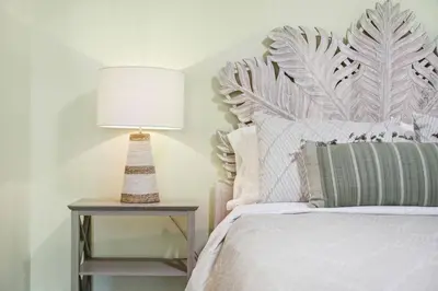 a bedroom with a bed and a lamp on a table at a block away from beach/Harbor/Fine restaurants in Panama City