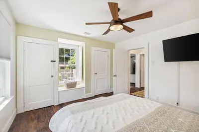 a bedroom with a ceiling fan and a flat screen tv at a block away from beach/Harbor/Fine restaurants in Panama City