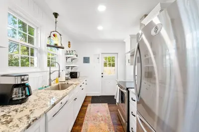 a white kitchen with a sink and a refrigerator at a block away from beach/Harbor/Fine restaurants in Panama City