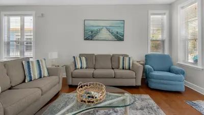 a living room with a couch and two chairs and a table at Walking on Waves in Santa Rosa Beach