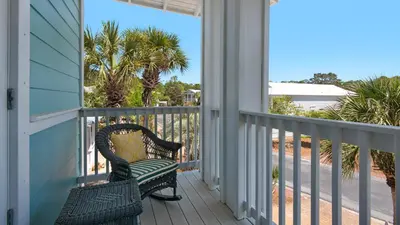 a porch with a bench and a view of the beach at Walking on Waves in Santa Rosa Beach