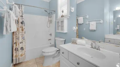 a white bathroom with a toilet and a sink at Walking on Waves in Santa Rosa Beach