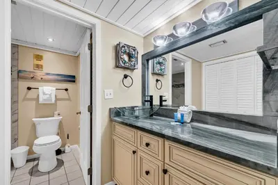 a bathroom with a sink and a toilet and a mirror at Edgewater Tower 1-608 in Panama City Beach
