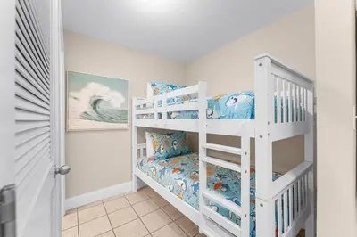a white bunk bed in a room with a bunk bed at Laketown Wharf #236 by Nautical Properties in Panama City Beach