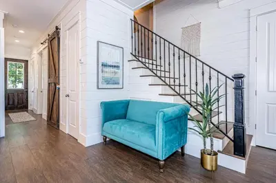 a blue chair in a hallway with a staircase at 9 E Willow Mist in Preserve at Inlet Beach in Inlet Beach