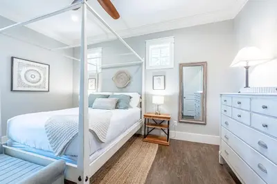 a white bedroom with a canopy bed and a dresser at 9 E Willow Mist in Preserve at Inlet Beach in Inlet Beach