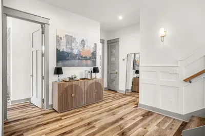 a living room with wooden floors and white walls at Blue Porch Paradise in Inlet Beach