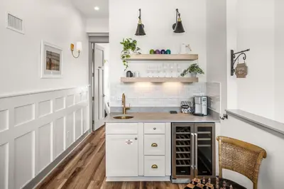 a kitchen with white cabinets and a wooden floor at Blue Porch Paradise in Inlet Beach