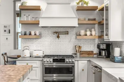a kitchen with white cabinets and a stove top oven at Blue Porch Paradise in Inlet Beach