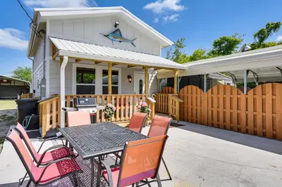 a patio with a table and chairs in front of a house at 13 Mi to St Andrews State Park Cabin with Patio! in Panama City