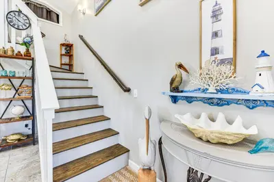 a staircase in a house with blue and white walls at 13 Mi to St Andrews State Park Cabin with Patio! in Panama City