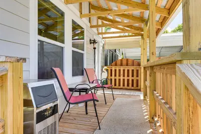 a patio with two chairs and a table on a house at 13 Mi to St Andrews State Park Cabin with Patio! in Panama City