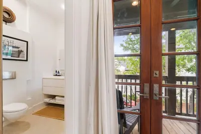 a bathroom with a toilet and a window at Vitamin Sea -Heart of Rosemary Beach. in Rosemary Beach
