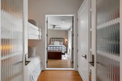 a hallway with a bedroom with a bed in it at Vitamin Sea -Heart of Rosemary Beach. in Rosemary Beach