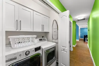 a kitchen with white cabinets and a washer and dryer at Caribbean feel,Mini&Disc Golf,Heated Pool,Game Rom in Panama City Beach