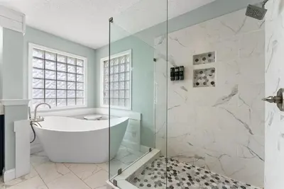 a bathroom with a tub and a glass shower stall at Caribbean feel,Mini&Disc Golf,Heated Pool,Game Rom in Panama City Beach