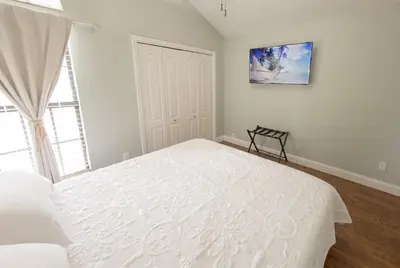 a white bedroom with a large bed and a window at Caribbean feel,Mini&Disc Golf,Heated Pool,Game Rom in Panama City Beach