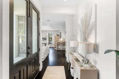 a living room with a hallway with a table and a door at 99 Sandy Shores Ct in Inlet Beach