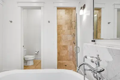 a bathroom with a shower and a sink and a toilet at Treetop Cottage in Rosemary Beach