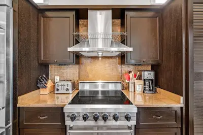 a kitchen with a stove and a microwave at Treetop Cottage in Rosemary Beach