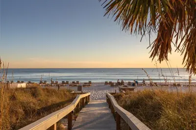 a boardwalk leading to the beach at sunset at Commodore 0502 in Panama City Beach