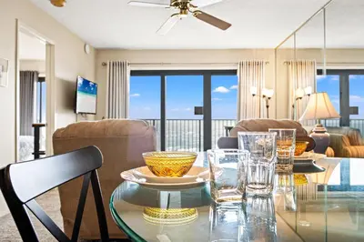 a dining room with a glass table with glasses on it at Commodore 0502 in Panama City Beach