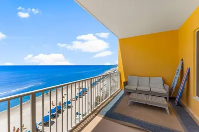 a balcony with a couch and the beach at Treasure Island #0401 in Panama City Beach