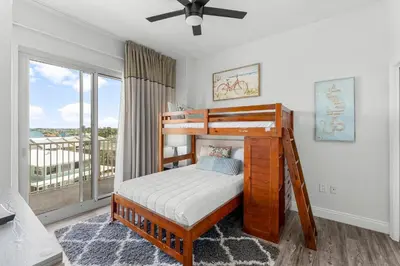 a bedroom with a bunk bed and a balcony at Treasure Island #0401 in Panama City Beach
