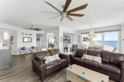 a living room with a couch and a ceiling fan at Treasure Island #0401 in Panama City Beach