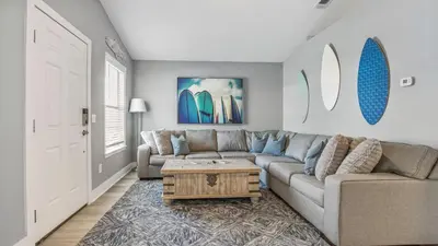 a living room with a couch and a coffee table at Blue & Red Neptune by Nautical Properties Vacation Rentals in Panama City Beach
